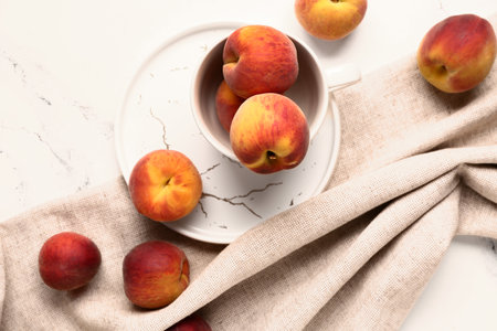 Cup with sweet peaches on white backgroundの写真素材