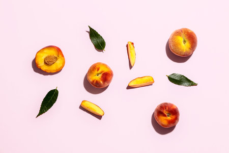 Sweet peaches and leaves on pink background