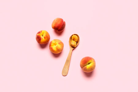 Sweet peaches and spoon on pink backgroundの写真素材