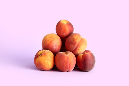 Heap of sweet peaches on lilac backgroundの写真素材