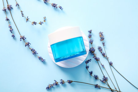Composition with jar of cosmetic product and lavender flowers on color backgroundの写真素材