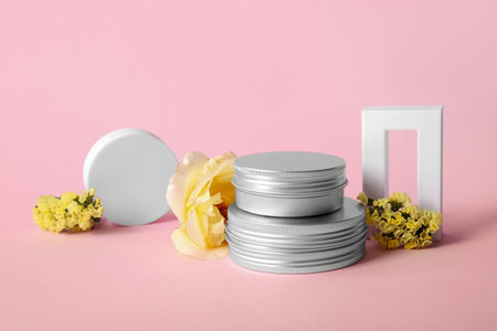 Composition with jars of cosmetic products and flowers on pink backgroundの写真素材