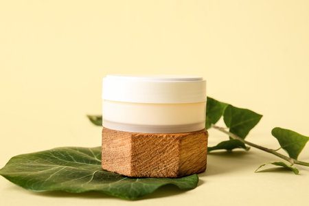 Composition with jar of cosmetic product and ivy branch on color backgroundの写真素材