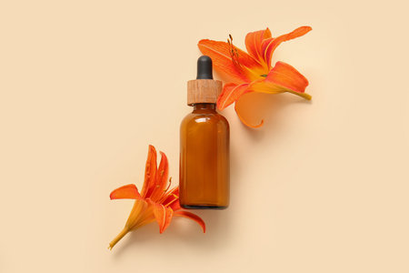 Bottle of essential flowers and lily flowers on color backgroundの写真素材