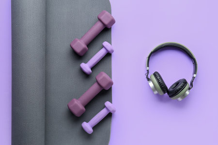 Set of dumbbells, headphones and yoga mat on lilac backgroundの写真素材