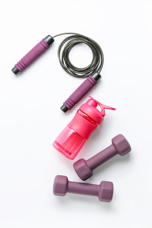 Bottle of water, dumbbells and skipping rope on white backgroundの写真素材