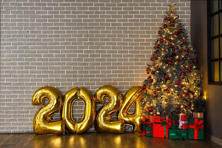 Balloons in shape of figure 2024 and Christmas tree with gifts near gray brick wall