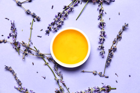 Bowl of sweet lavender honey and flowers on blue backgroundの写真素材