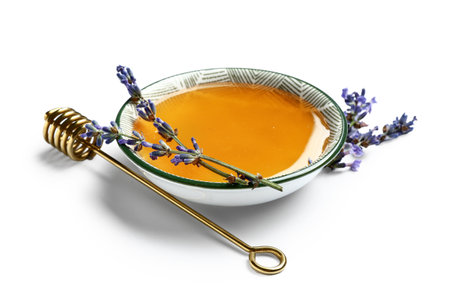 Bowl of sweet lavender honey, dipper and flowers on white backgroundの写真素材