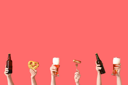 Many hands with cold beer, sausage and pretzel on red backgroundの写真素材