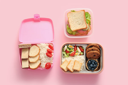 Lunchboxes with different delicious food on pink backgroundの写真素材