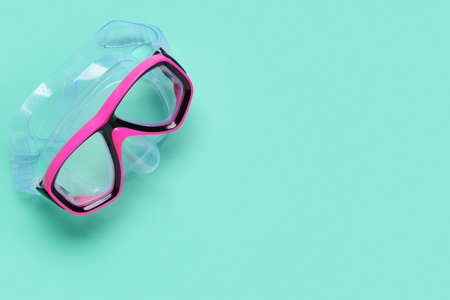 Pink swimming mask on turquoise background