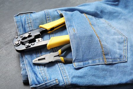 Jeans with different tools in pocket on black grunge background. labor day celebrationの写真素材