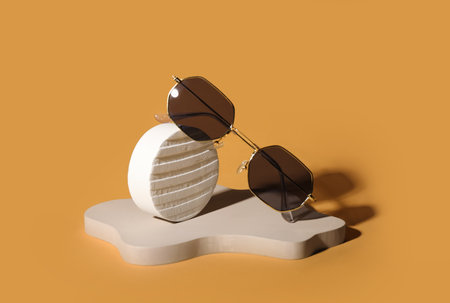 Stands with stylish retro sunglasses on orange backgroundの写真素材