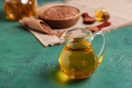 Jug with flax oil on green backgroundの写真素材