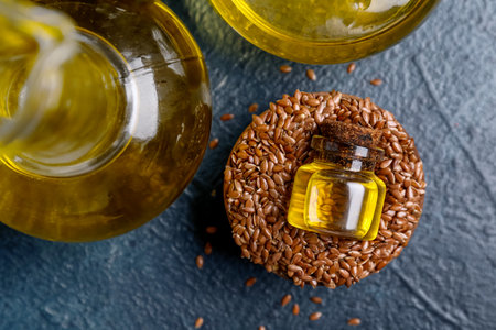 Jar of flax oil and bowl with seeds on blue backgroundの写真素材