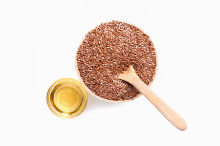 Glass bowl of flax oil and seeds on white backgroundの写真素材