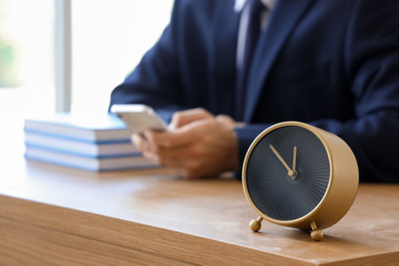 Alarm clock on table of businessman in office, closeupの写真素材