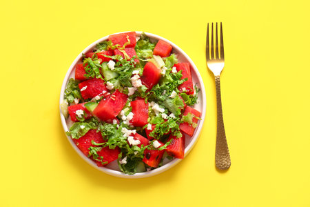 Plate of tasty watermelon salad on yellow backgroundの写真素材