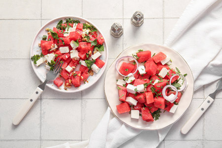 Plates of tasty watermelon salad on white tile backgroundの写真素材