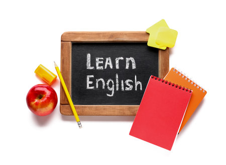 Stationery and blackboard with text LEARN ENGLISH isolated on white backgroundの写真素材