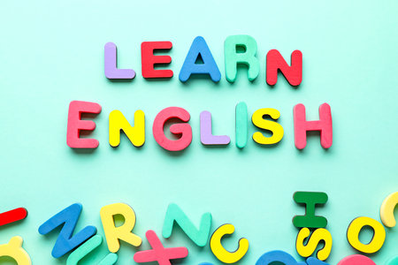 Text LEARN ENGLISH and wooden letters on turquoise backgroundの写真素材