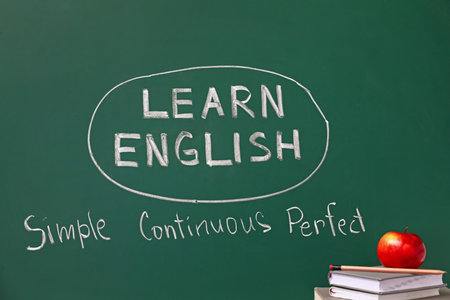 Blackboard with text LEARN ENGLISH and stationery on tableの写真素材