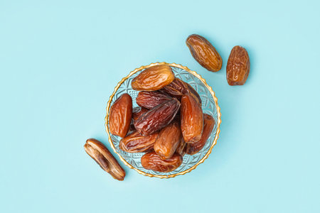 Bowl with dried dates on blue backgroundの写真素材