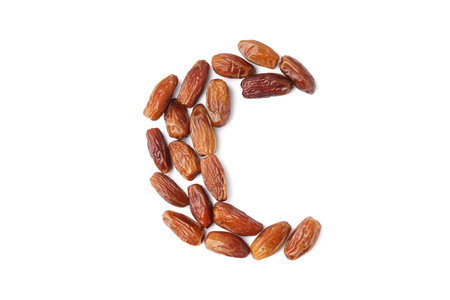 Crescent made of dried dates on white background