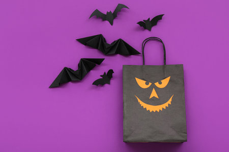 Composition with shopping bag and bats for Halloween on purple backgroundの写真素材