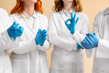 Doctors in medical gloves gesturing on beige background, closeupの写真素材