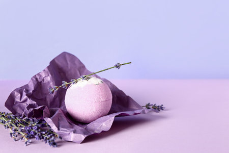 Crumpled paper with bath bomb with lavender flowers on color backgroundの写真素材