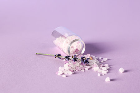 Bottle of sea salt and lavender flower on color backgroundの写真素材