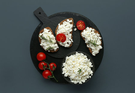 Tasty sandwiches with cottage cheese and tomatoes on black backgroundの写真素材