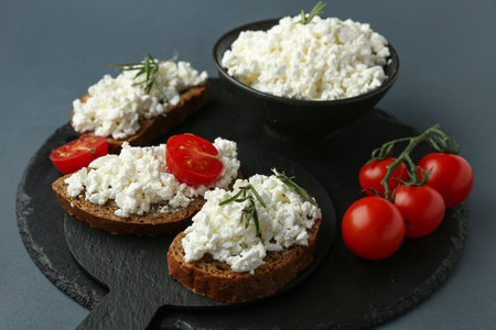Tasty sandwiches with cottage cheese and tomatoes on black backgroundの写真素材
