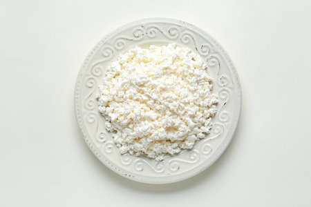 Plate of tasty cottage cheese on white backgroundの写真素材