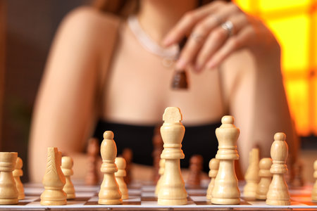 Woman and chess pieces on game board, closeupの写真素材