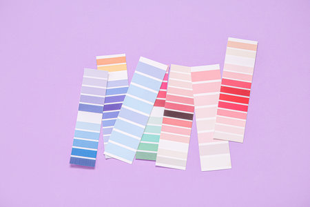 Many color palettes on lilac background, top view