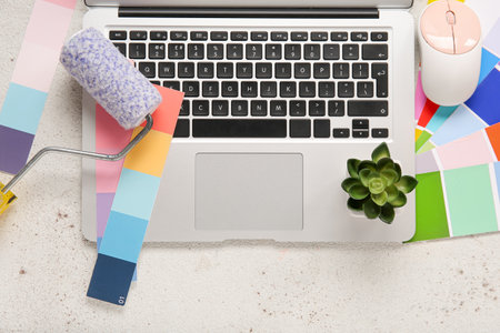 Color palettes, paint roller and laptop on light background, top viewの写真素材