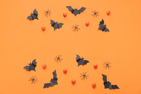 Composition with pumpkins, paper bats and spiders on orange background. halloween celebration conceptの写真素材