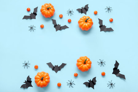Composition with pumpkins, paper bats and spiders on blue background. halloween celebration conceptの写真素材