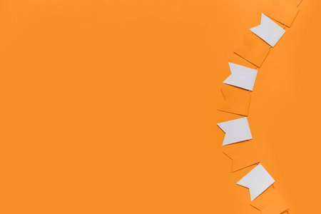 Garland made of paper flags for Halloween celebration on orange backgroundの写真素材