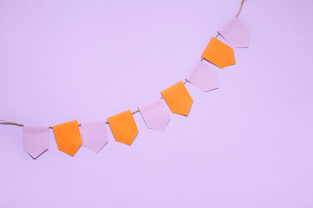 Garland made of paper flags for Halloween celebration on purple backgroundの写真素材