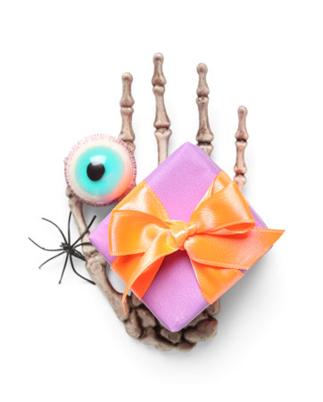 Composition with skeleton hand, spider, candy and gift box for Halloween on white backgroundの写真素材