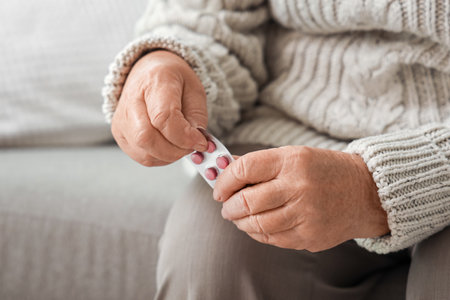 Elderly woman with pills at home, closeupの写真素材