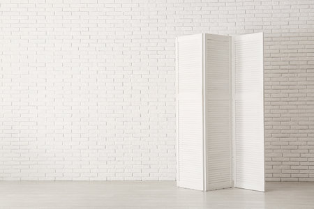 Folding screen near white brick wallの写真素材