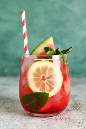 Glass of fresh watermelon lemonade with mint on gray tableの写真素材