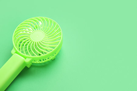 Modern manual fan on green background, closeupの写真素材