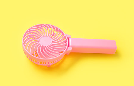 Modern manual fan on yellow background, closeupの写真素材
