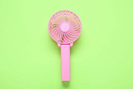 Modern manual fan on green backgroundの写真素材